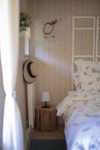 a bedroom with a bed and a hat on a table at Au Bois Dormant gîte 15 personnes in Lapoutroie +39 photos