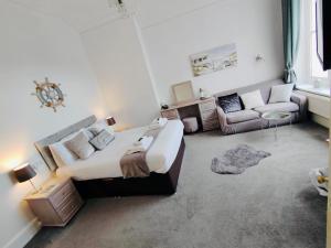 a bedroom with a large bed and a couch at Bay Court in Llandudno