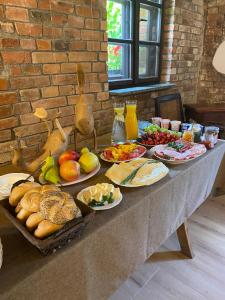 a table with many plates of food on it at Apartament w Zabytkowej Stajni nad Jeziorem z Dostępem do Parku i Sąsiedztwem XIX wiecznego Dworku Modrzewiowego in Szteklin