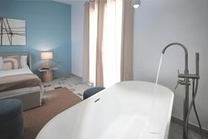 a living room with a white table and a bed at ACQUA PETRA Pool Villa & Suites in Agrigento