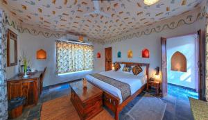 a bedroom with a bed and a ceiling with birds on it at Alaya Stays Bagh Serai, Ranthambore in Mokholī