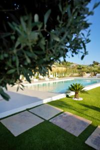 アグリジェントにあるACQUA PETRA Pool Villa & Suitesの芝生の庭があるリゾート内のスイミングプール