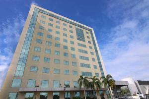 利尼亚雷斯Quarto duplo Samba Hotel Linhres的一座前面有棕榈树的高楼