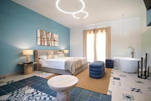 a bedroom with a bed and a tub and a sink at ACQUA PETRA Pool Villa & Suites in Agrigento
