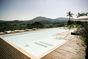 a swimming pool with a chair and a table at 3Encostas in Cabeceiras de Basto
