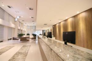 利尼亚雷斯Quarto duplo Samba Hotel Linhres的大堂设有前台,墙上配有电视
