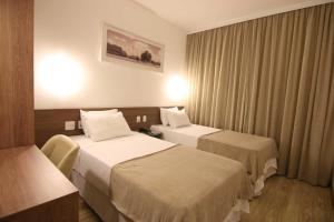 利尼亚雷斯Quarto duplo Samba Hotel Linhres的酒店客房,设有两张床和窗帘