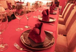 a long table with red table cloth and wine glasses at Hostal Boutique Tolox Sierra de las Nieves in Tolox