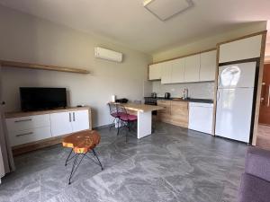 Yassı AdaNima apart otel datça的厨房里有一张桌子和一个冰箱