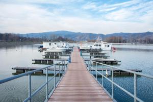 a dock on a lake with boats in the water at Nobus Vila jezero in Veliko Gradište