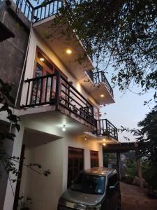 a car parked in front of a house with a balcony at Kandy Nivahana Heights Homestay in Kandy +24 photos
