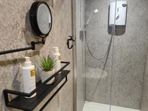 a bathroom with a shower with a mirror at Wheelgate in Torver +67 photos