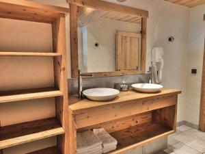une salle de bain avec deux lavabos sur un comptoir en bois avec un miroir dans l'établissement Luxueux 6 pièces avec sauna, hammam et jacuzzi, à 300m du centre et au pied des télécabines! - FR-1-458-95, au Grand-Bornand 28 autres photos
