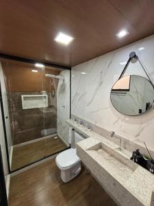 a bathroom with a shower and a toilet and a sink at Chalé Aconchego in Alto Caparao