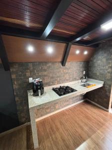a kitchen with a stove and a counter top at Chalé Aconchego in Alto Caparao