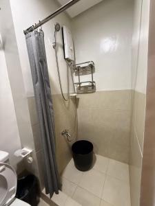 a bathroom with a shower curtain and a toilet at Condo in Fairview SM Terraces Cozy Netflix in Manila