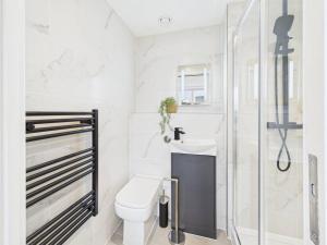 a white bathroom with a toilet and a shower at Luxury Two Bed | Sleeps 6 | 5 beds in Brent Station