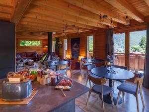 a room with tables and chairs and a living room at Chalet LE VAL NESS in La Côte dʼArbroz