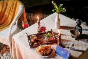 a table with a tray of food and candles on it at SaffronStays Aquadome Celeste -River Access Stay in Bhikia Sain