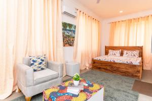 a bedroom with a bed and a chair and a table at MG Villa, Zanzibar in Mfumbwi +20 photos