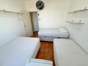Zimmer mit 2 Betten und einer Uhr an der Wand in der Unterkunft Quarto individual na Pituba 1 in Salvador
