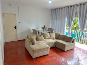 ein Wohnzimmer mit Sofa und Tisch in der Unterkunft Quarto individual na Pituba 1 in Salvador