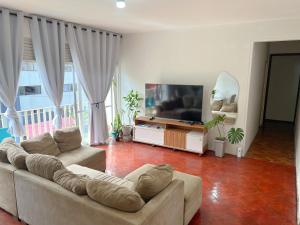 ein Wohnzimmer mit zwei Sofas und einem Flachbildfernseher in der Unterkunft Quarto individual na Pituba 1 in Salvador + 10 Fotos