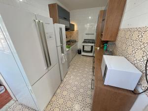 Il comprend une cuisine équipée d'un réfrigérateur et d'une cuisinière. dans l'établissement Quarto individual na Pituba 1, à Salvador