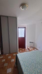 a bedroom with a bed and a red door at petit esperantza in Saint-Pée-sur-Nivelle