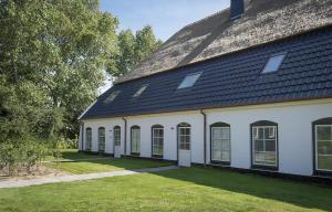 a large white building with a black roof at G-21A Bouwlust in De Cocksdorp