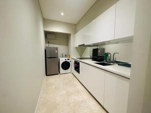 吉隆坡vortex suites klcc by twin tower vibes的配有白色橱柜、洗衣机和烘干机的厨房