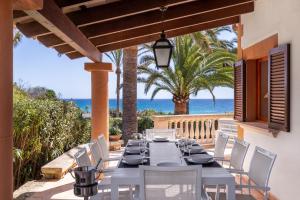 una mesa de comedor y sillas en un patio con vistas al océano en Sembat de Mar, en Cala Millor
