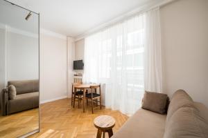 a living room with a couch and a table at Widok Warsaw City Apartment by BookingHost in Warsaw