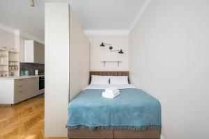 a bedroom with a bed with a blue blanket at Widok Warsaw City Apartment by BookingHost in Warsaw