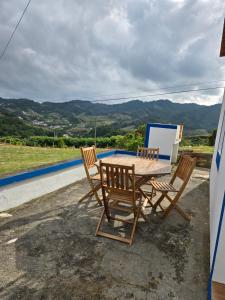 a table and chairs on the balcony of a house at casa Eira Alta in Santa Bárbara