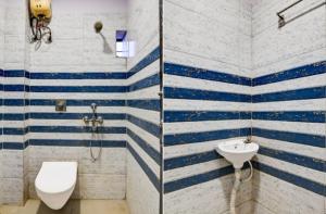 a bathroom with blue and white stripes on the walls at Hotel Sana a family-friendly guest house in Kolkata