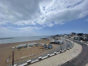 einen Strand mit einer Straße am Meer in der Unterkunft Le Monte Cristo in Les Bussolleries