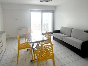 ein Wohnzimmer mit Tisch, Stühlen und Sofa in der Unterkunft Le Monte Cristo in Les Bussolleries