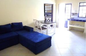 a living room with a blue couch and a table at FRIDULI SHILOH Resort in Diani Beach