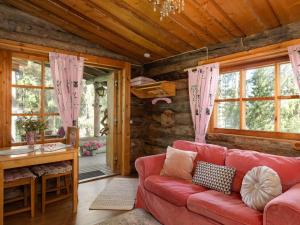 a living room with a red couch in a cabin at Holiday Home Rinnekämppä by Interhome in Pätiälä