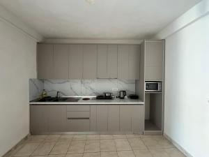 a kitchen with white cabinets and a counter top at Ibras House in Durrës