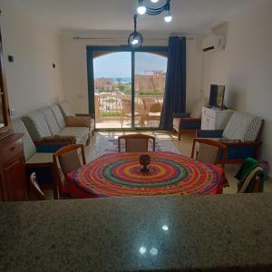 a living room with a table and chairs and a large window at See your sea in Ras Sedr