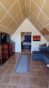 a living room with a couch and a bed at Cabaña Montaña Azul Boquete in Alto Boquete