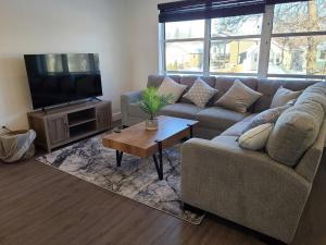 a living room with a couch and a tv at Entire New Built - Spacious 3-bedroom Suite. in Regina