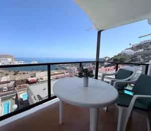 un tavolo su un balcone con vista sull'oceano di Guayarmina a Puerto Rico de Gran Canaria