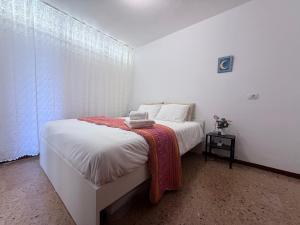 una camera da letto con un letto bianco con una coperta sopra di Guayarmina a Puerto Rico de Gran Canaria