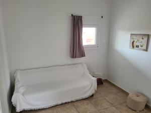 a white bed in a room with a window at Sea View House in Porto Rafti