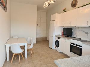 a kitchen with white cabinets and a table and chairs at Sea View House in Porto Rafti