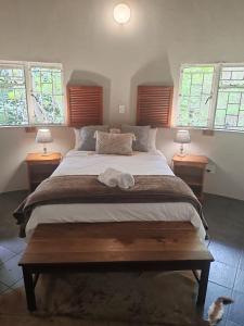 une chambre avec un grand lit avec deux tables de nuit dans l'établissement Rhenosterkop Cottages, à Nelspruit