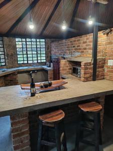 un bar avec deux tabourets et une table avec une bouteille de vin dans l'établissement Rhenosterkop Cottages, à Nelspruit